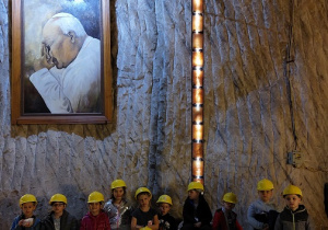 Grupowe zdjęcie pod tablicą papieża Jana Pawła II.