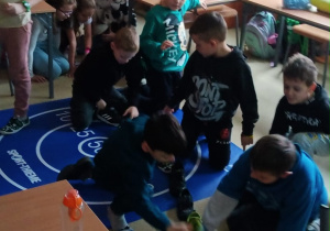 Uczniowie przekładają buty na podłodze