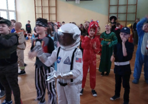 Uczeń przebrany za kosmonautę tańczy.