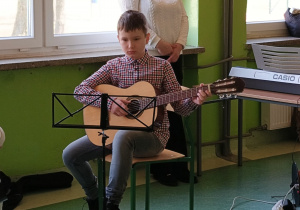 Uczeń gra na gitarze