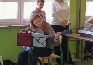 Uczennica gra na gitarze