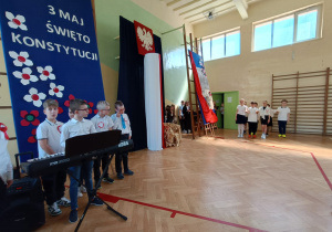 Uczniowie tańczą poloneza, chłopiec gra na keyboardzie