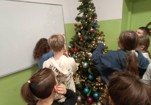 dzieci ubierają choinkę