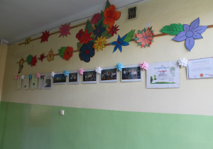 Zdjęcia klas i certyfikaty na korytarzu przed stołówką